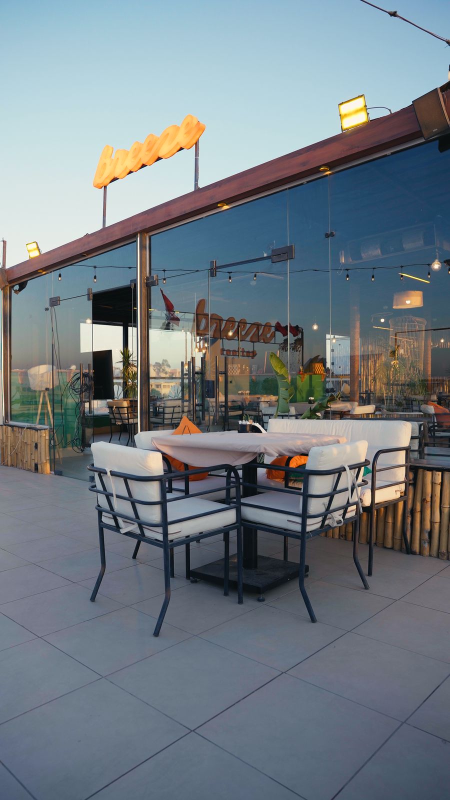 Breeze rooftop at sunset, glowing neon sign over the seating